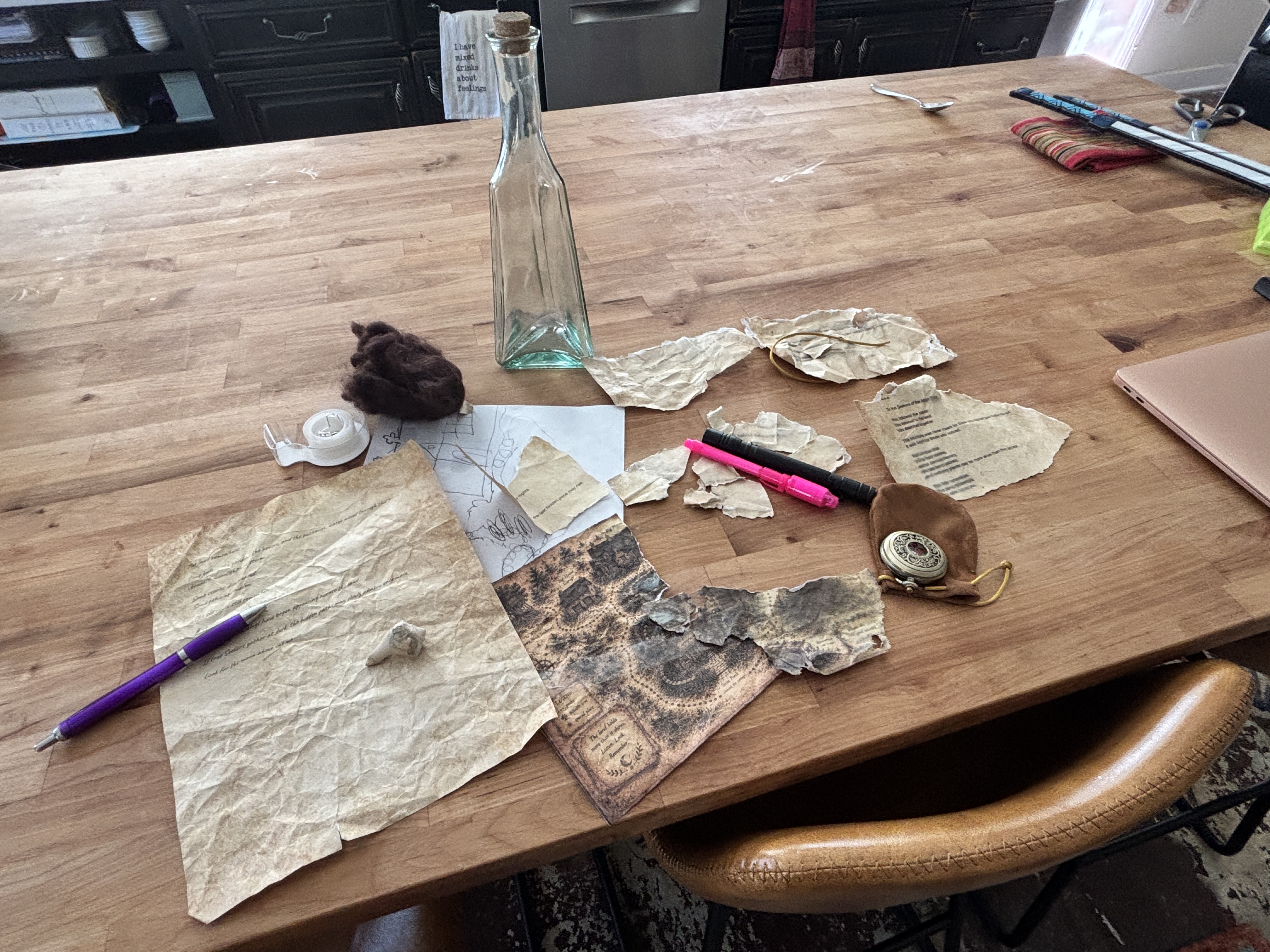 Moon Water clue fragments, bottle, map pieces, compass, and tools spread across a table